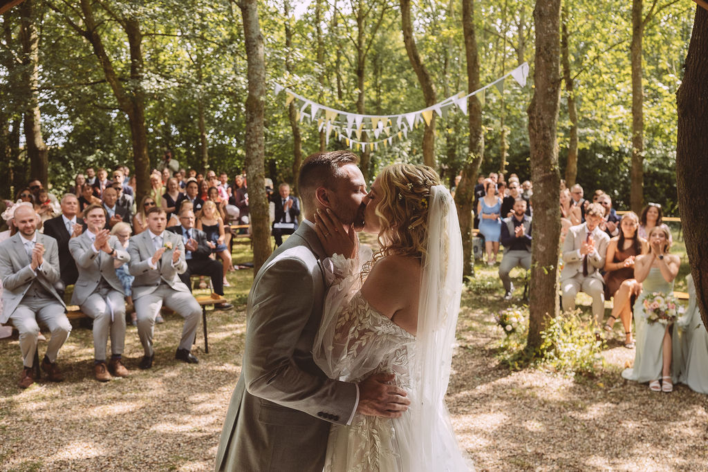 Bride groom kissing after outdoor ceremony
