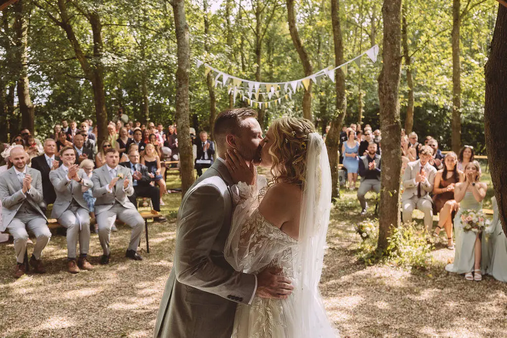 Bride groom kissing after outdoor ceremony
