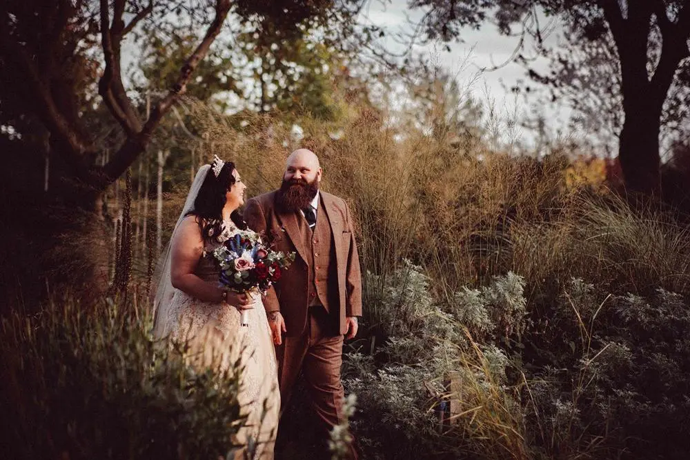 Bride and groom walking in woodland