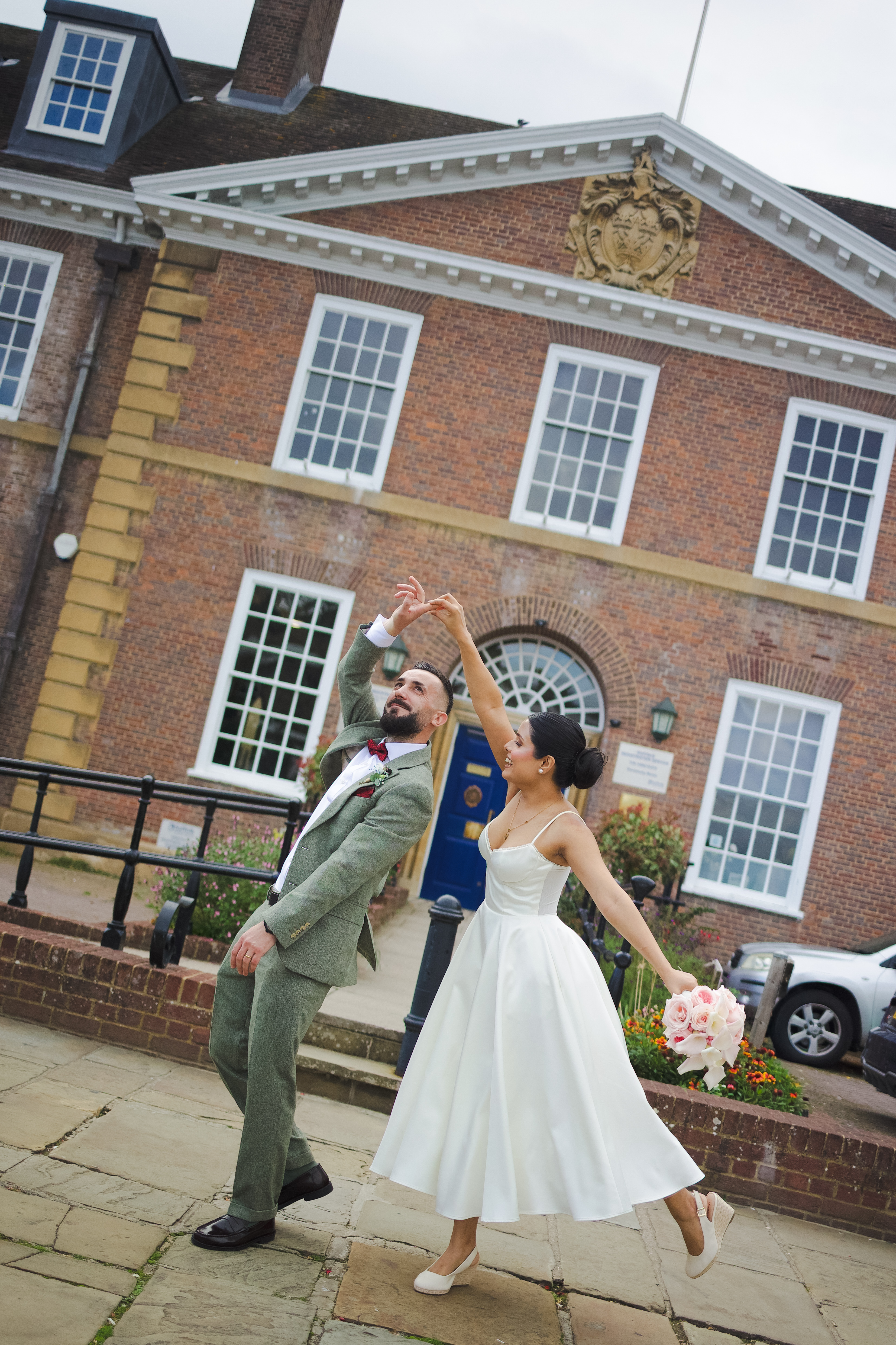 Bride and groom twirling in front of Bury Register  office
