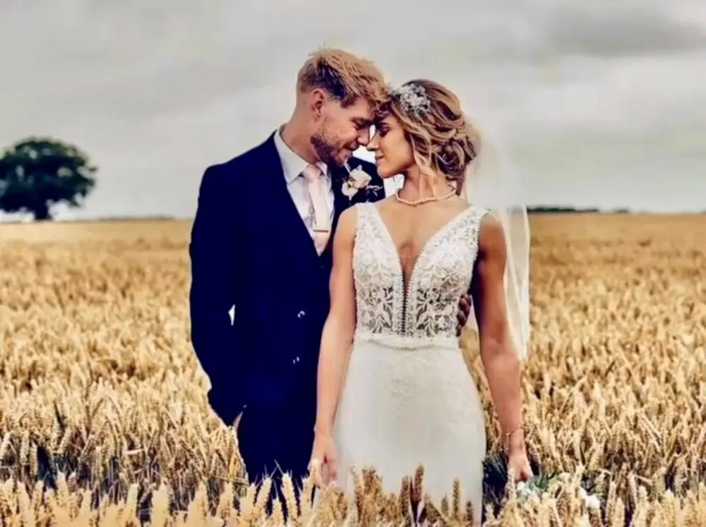 Bride and groom standing in corn field