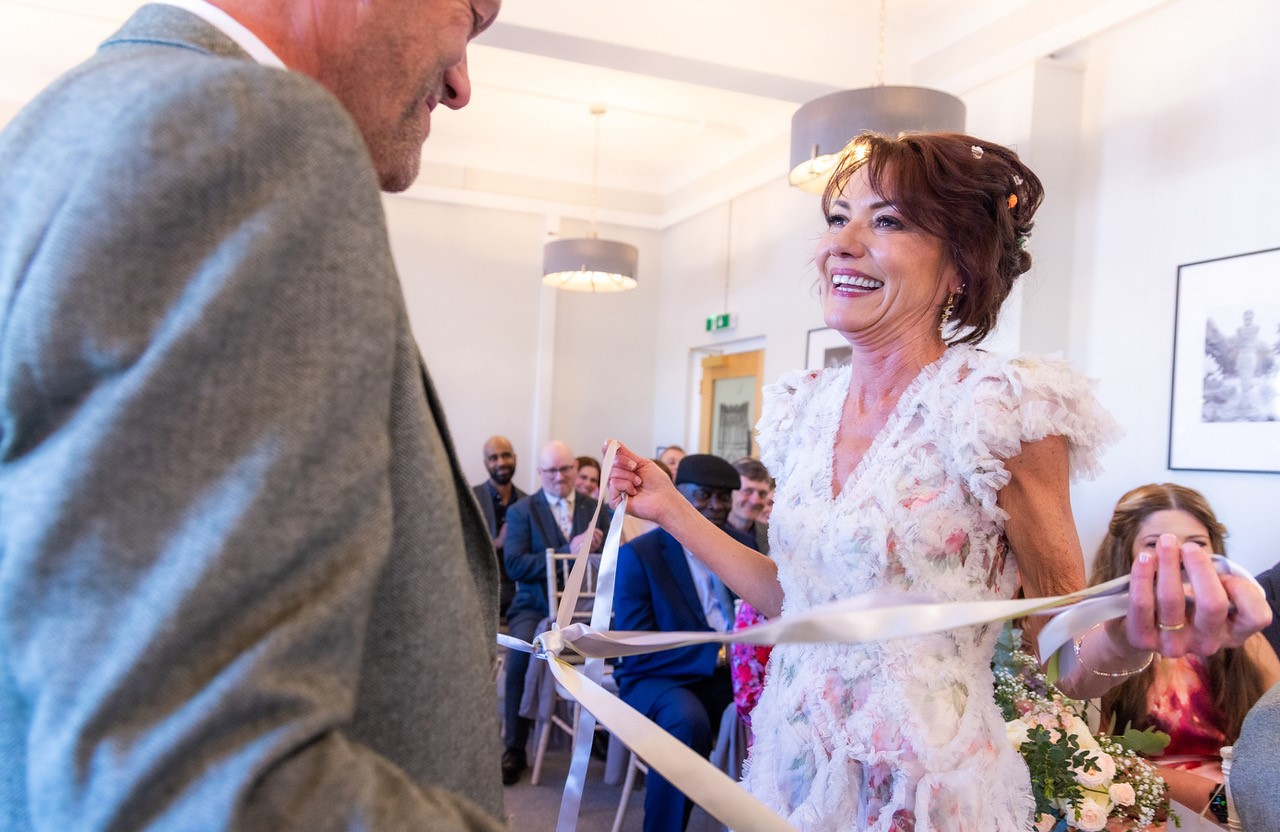 Bride smiling at groom at a tying the knot ceremony at the Bury St Edmunds register office