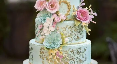 Bridgerton style four tier wedding cake with extravagant floral decorations