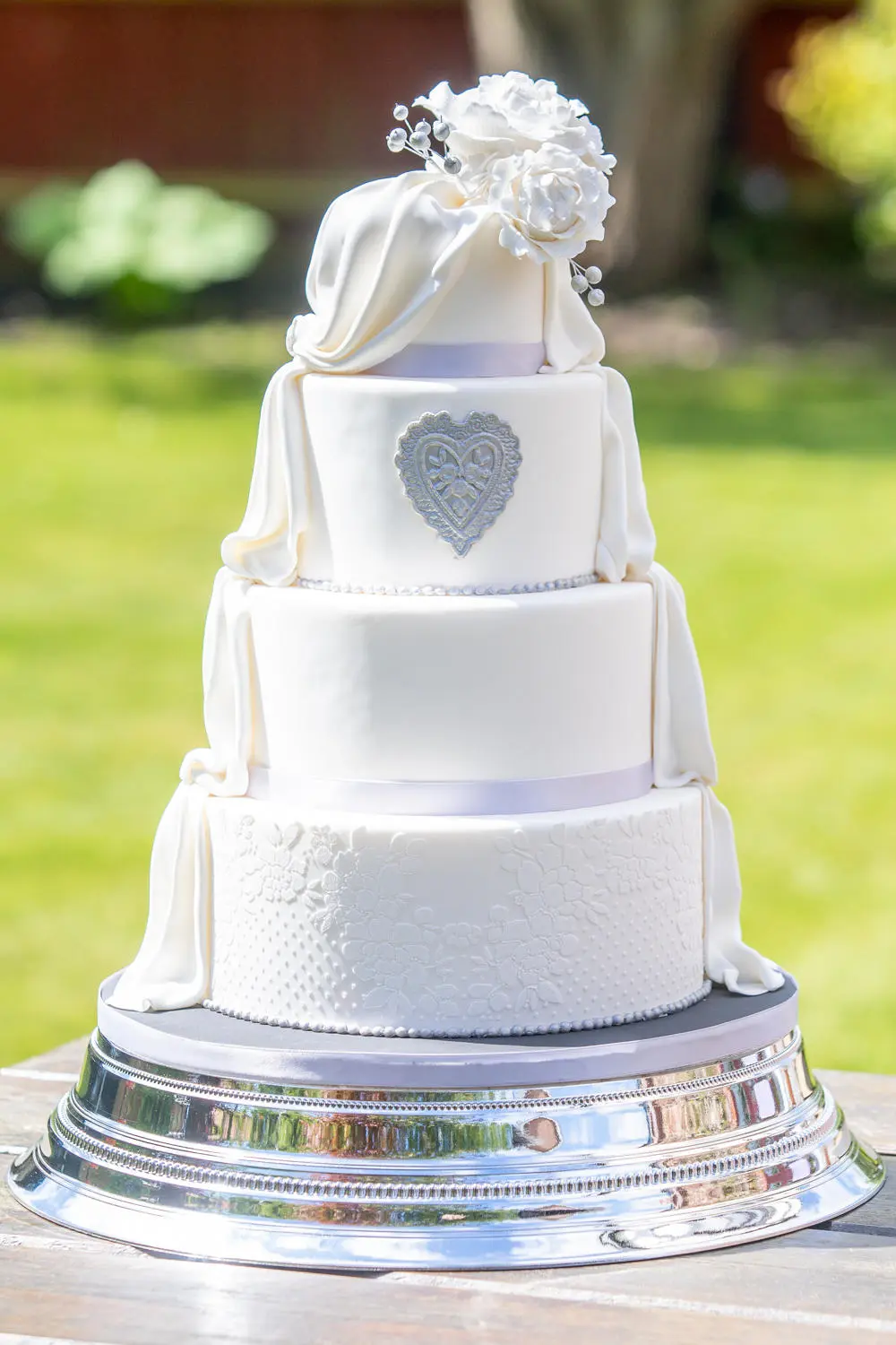Beautiful three tiered wedding cake with white sugar coating on silver plate