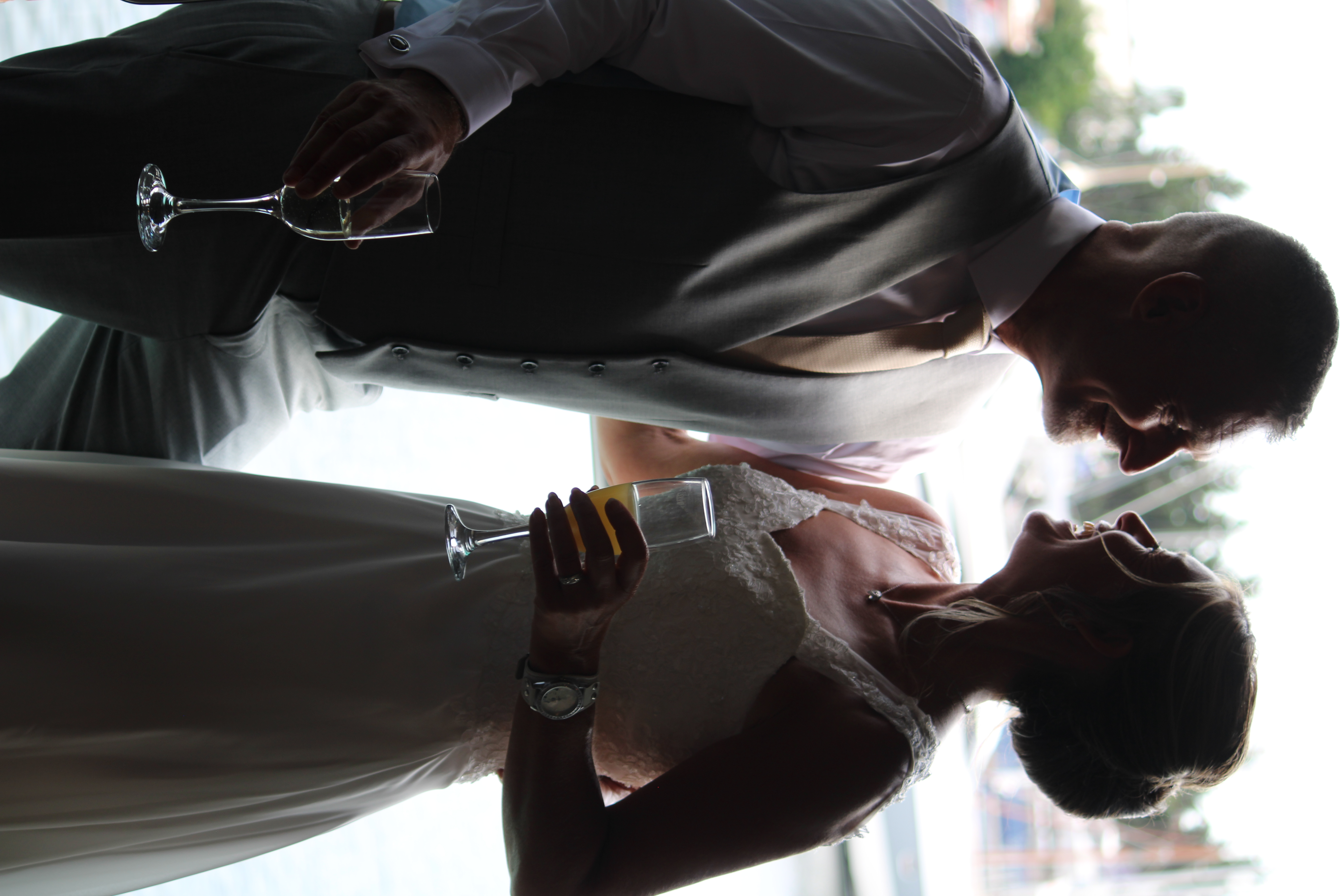 Bride and groom with champagne glasses smiling at each other