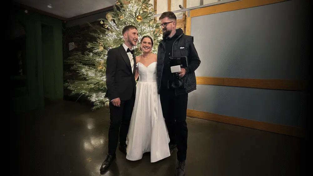 CV Film Videographer standing with couple in front of Christmas tree