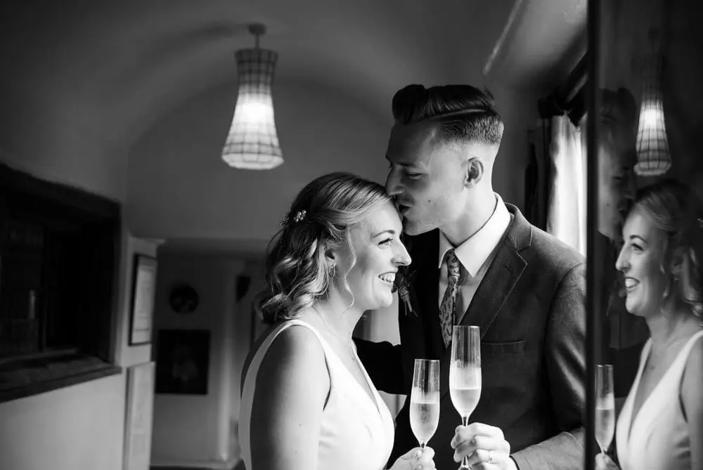 Bride and groom kissing elegant black and white photo by Denise Brady