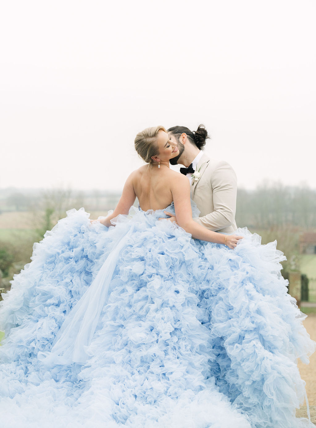 Couple kissing in field bride swooning