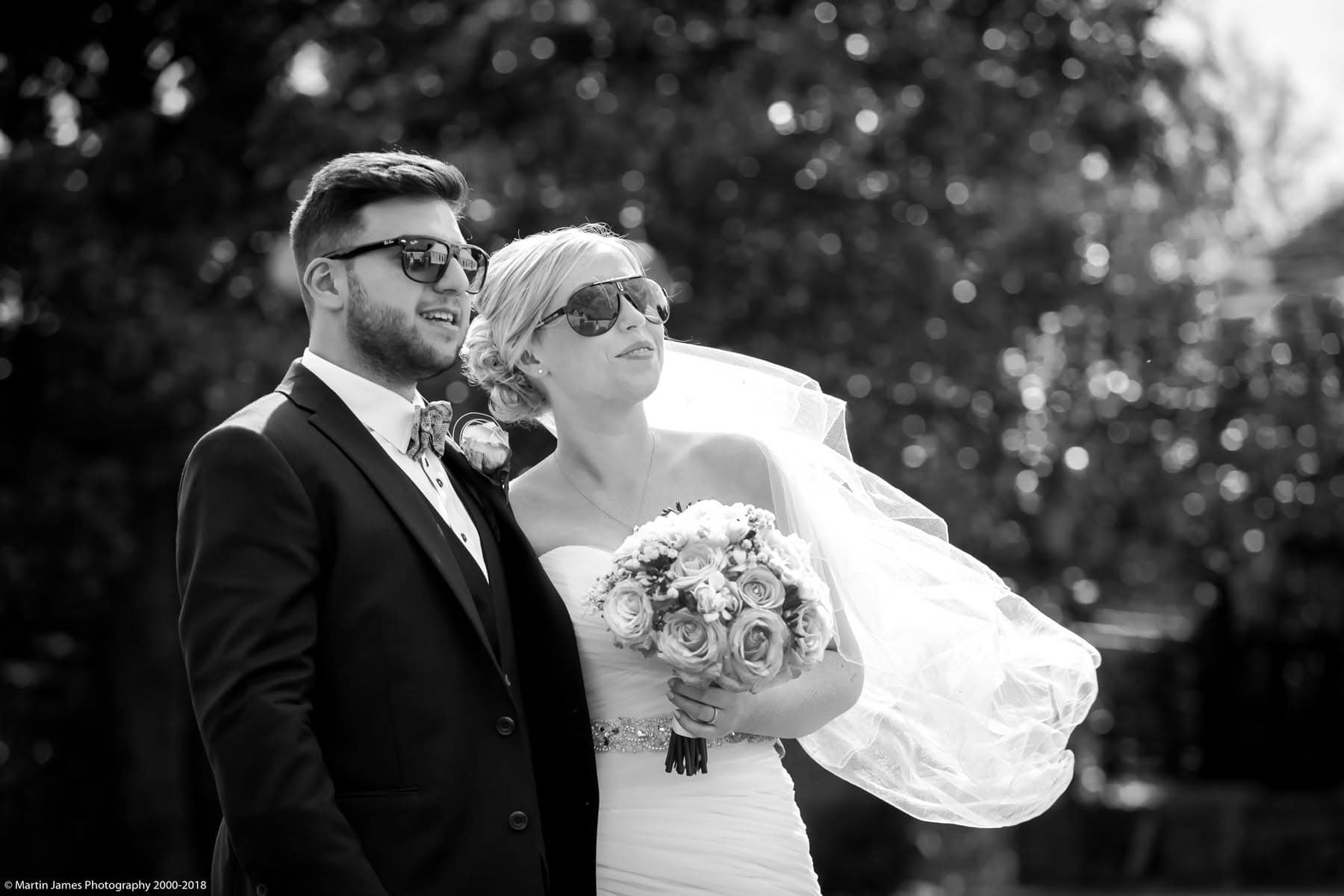 Black and white image of bride and groom with sunglasses