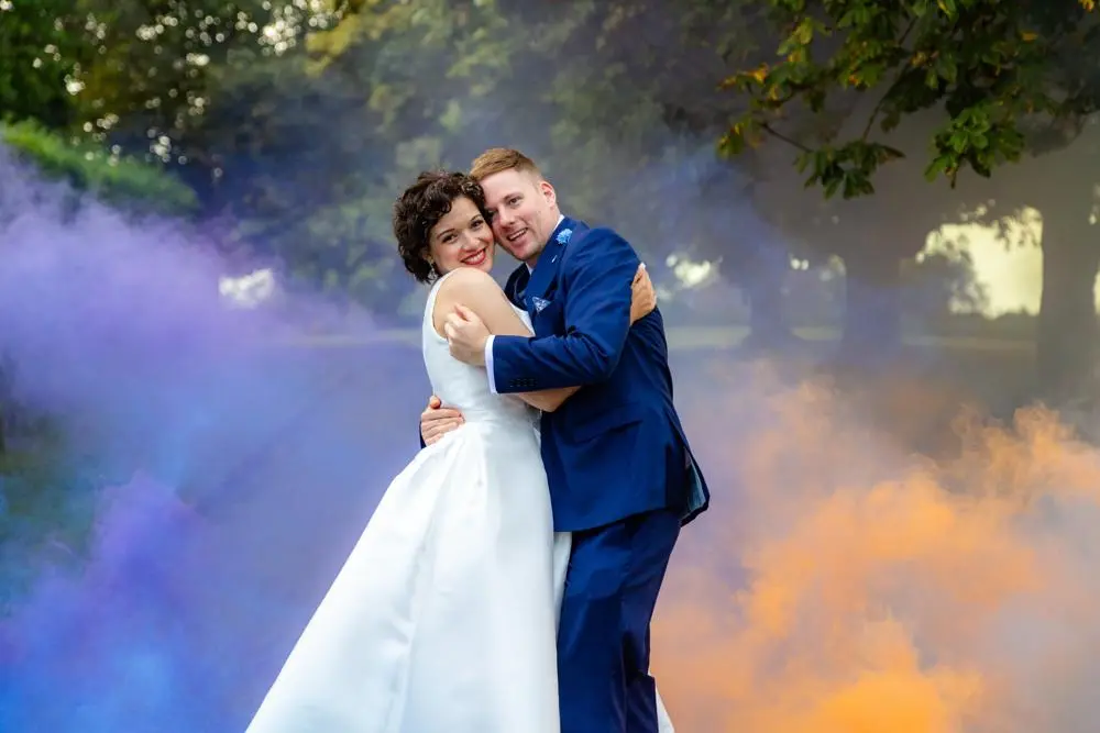 Bride and groom hugging in front of flares
