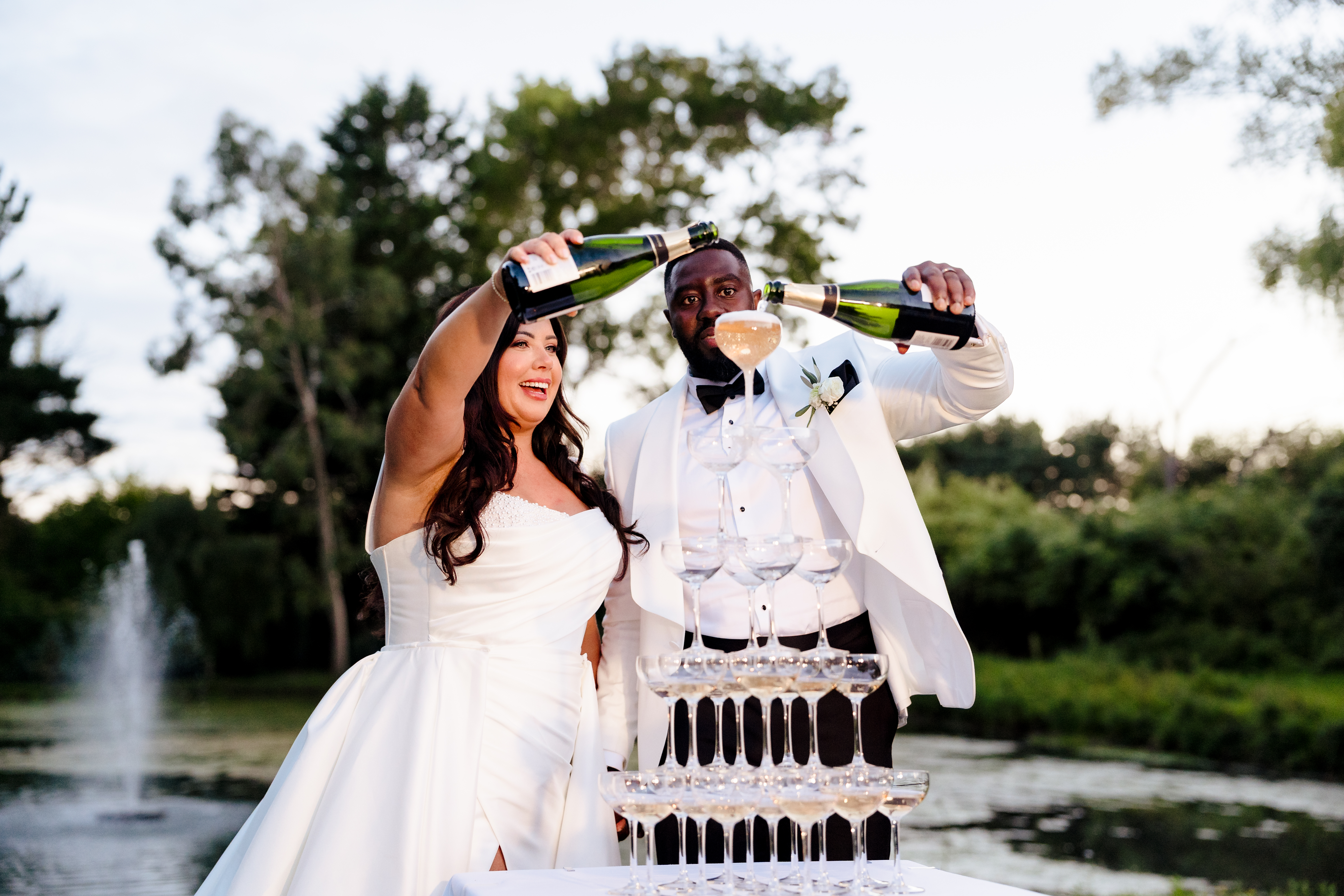 Bride and groom filling champagne tower