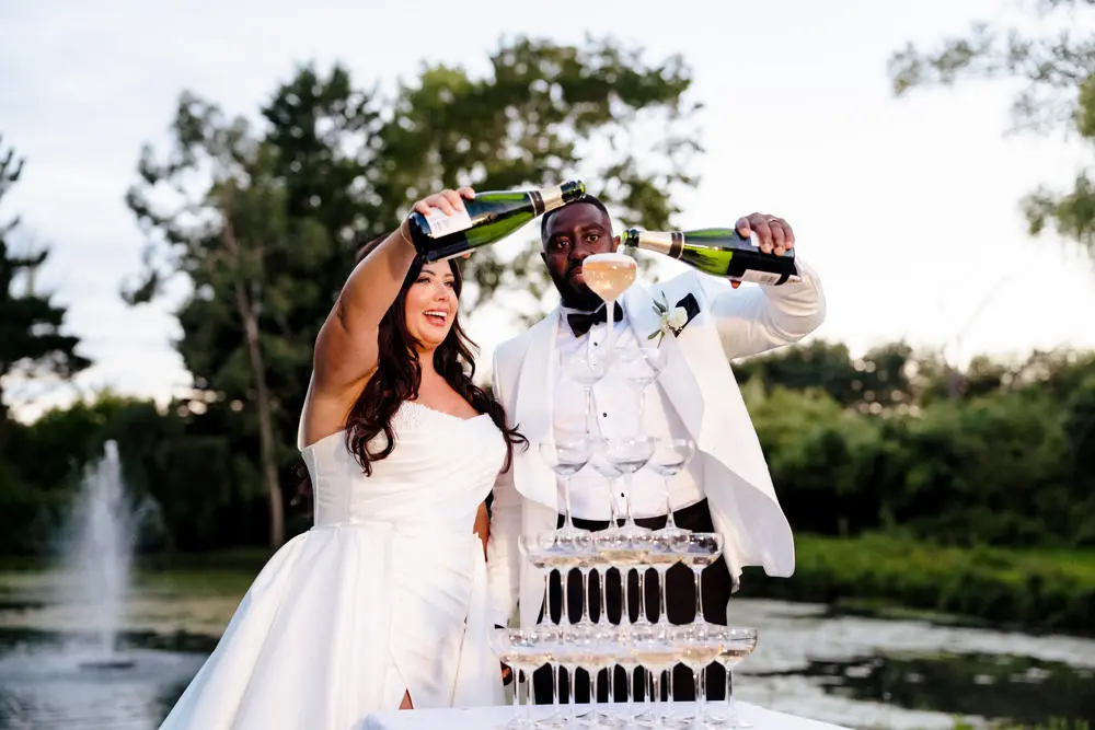 Bride and groom filling champagne tower