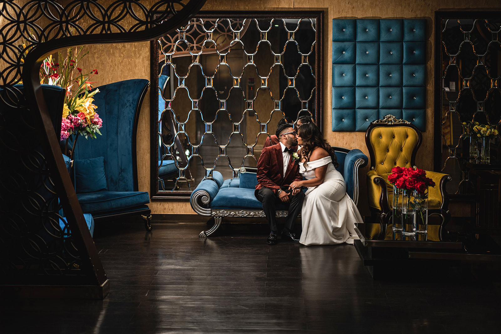 Bride and Groom sitting on sofa kissing in opulent room