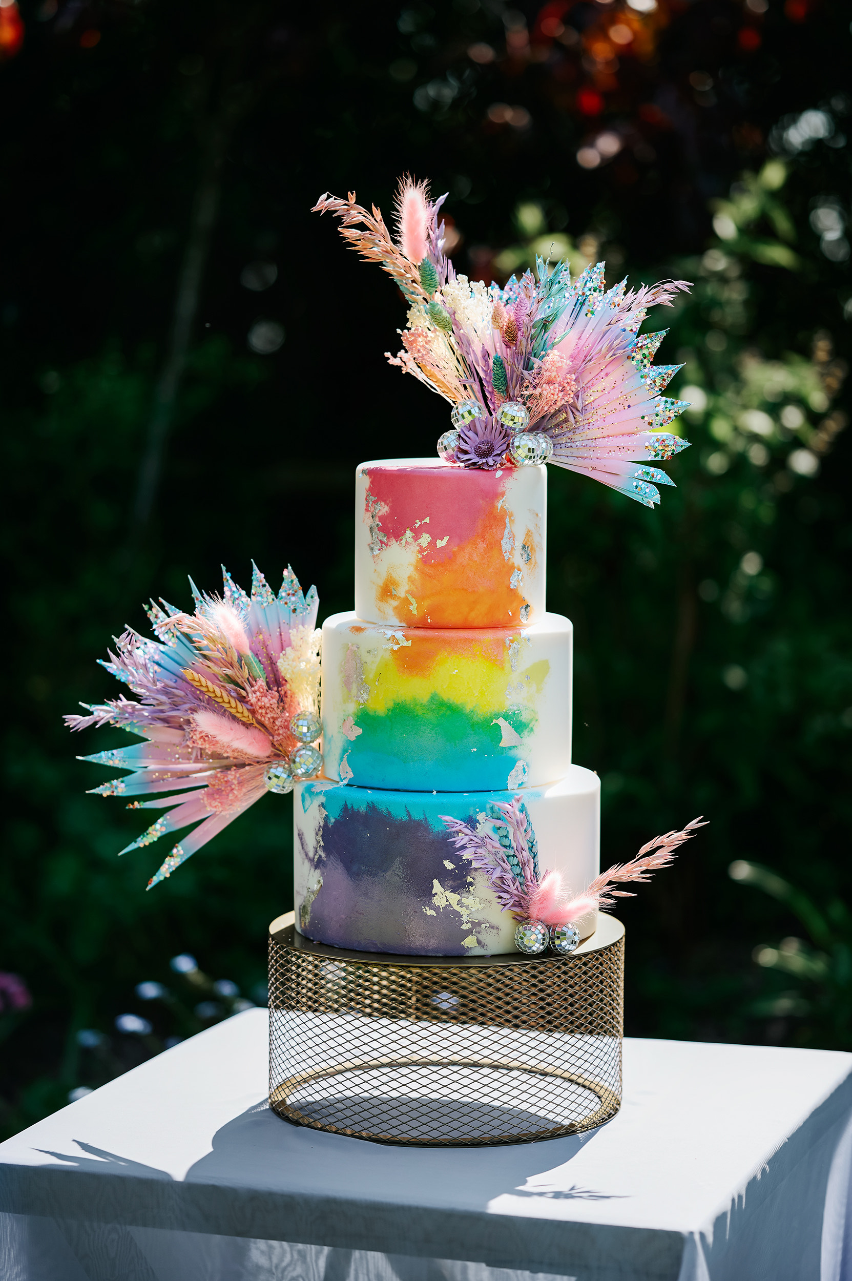 Three tiered wedding cake with rainbow decorations