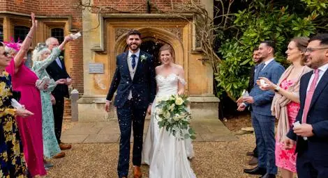 Bride and groom walking through confetti shower