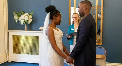 Bride and groom holding hands in front of Registrar during their wedding ceremony