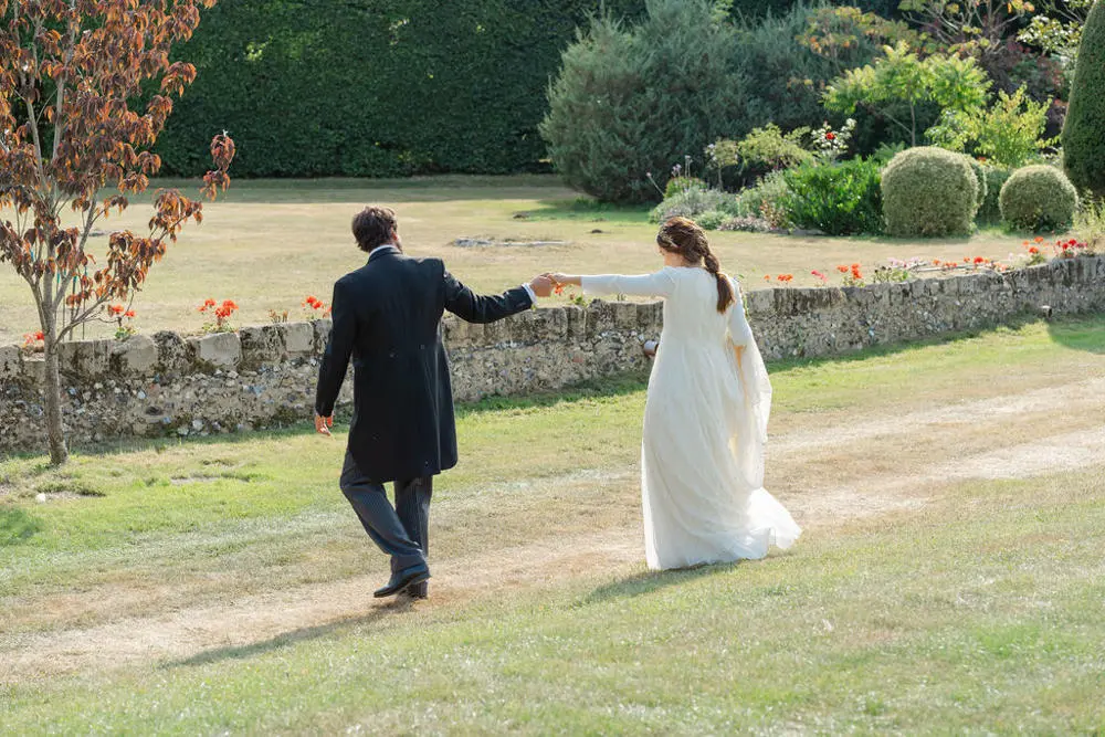 Bride and groom walking across field