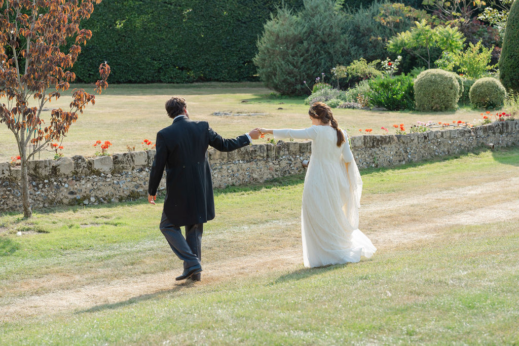 Bride and groom walking across field