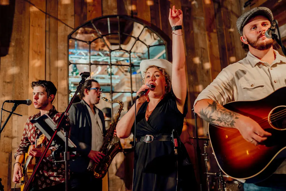 Country band with two guitars and one singer playing in barn