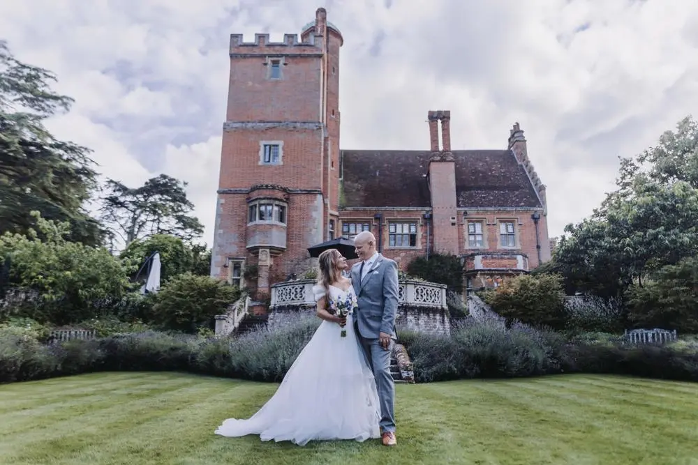 bride and groom on lawn outside wedding venue