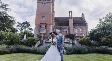 bride and groom on lawn outside wedding venue